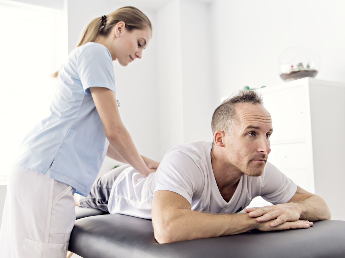 Patient at the physiotherapy doing physical exercises with his therapist